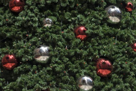 An artificial Christams tree background with red and silver metallic baubles