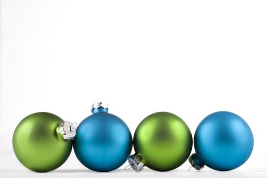 Blue and green Christmas ornaments lined up, isolated
