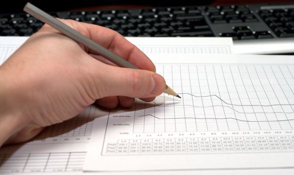 Hand with a pencil over sheet with the schedule.