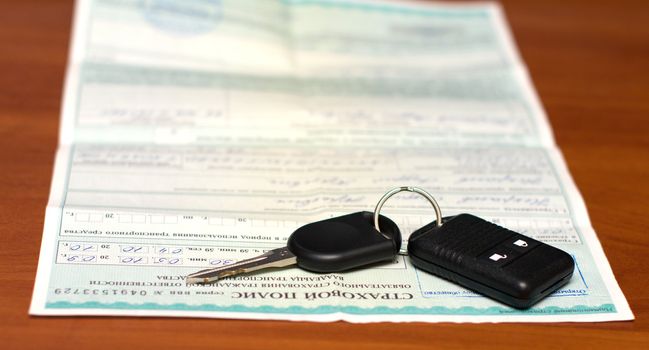 Insurance policy and key from the car about an alarm system charm.