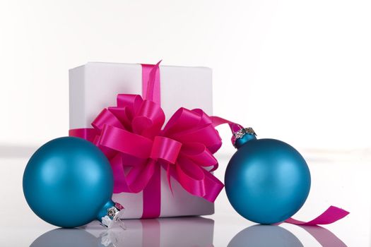 White present with pink ribbons and blue ornaments, isolated