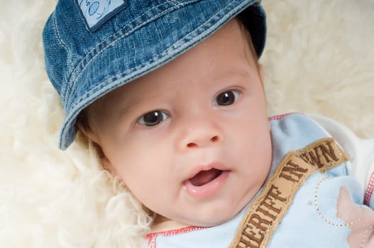 Shot of trendy newborn boy in denim cap