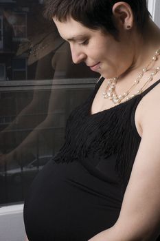 Late twentie pregnant woman in old fashion evening dress with urban background