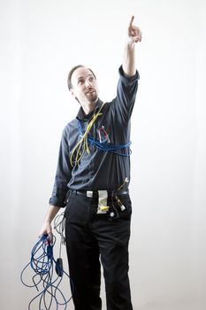 Computer technician pointing to the sky wearing many different kind of computer cables and wire