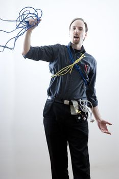 Computer technician, wearing many different kind of cables and wires, falling backwards holding on to a blue network cable