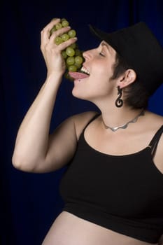 Twenty something women in boyish look eating green grapes