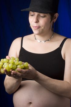 Pregnant women choosing green grapes 