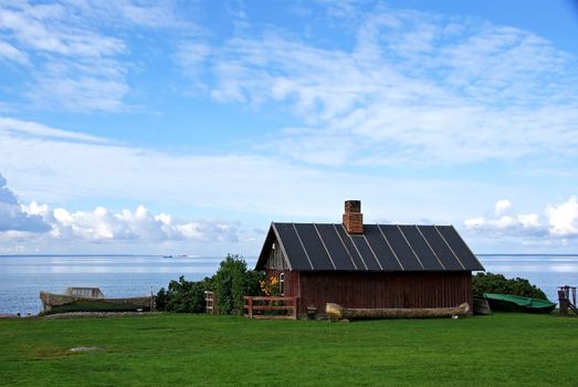 The wooden house and boats on seacoast