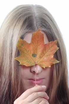 The nice girl closing the person an autumn maple leaf