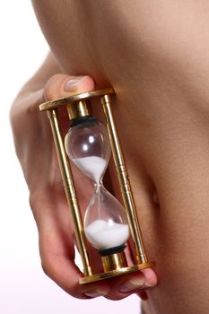 Female body with a sand-glass before a stomach removed close up