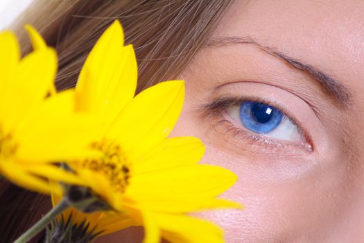 Female eye with a yellow flower removed close up