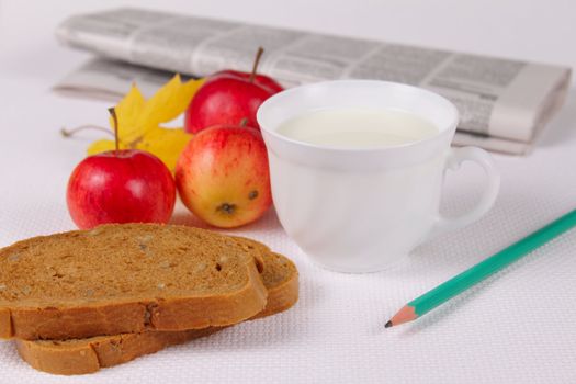 Bread with milk and apples against a morning paper removed close up