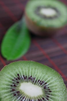 The cut fruit kiwi on a bamboo napkin removed close up