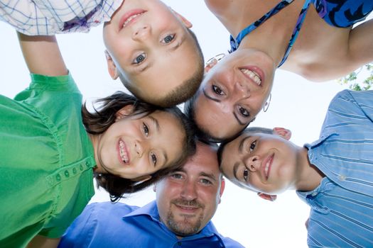 A happy family posing in a group huddle formation.