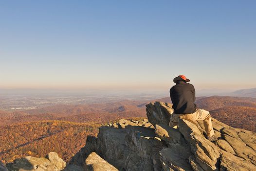 Man reflecting life while sitting on Humpback Rock in the Blue Ridge Mountains of Virgina.  The hike to this scenic overlook is about 1 mile straight up, an acheivement for any hiker.  Room for text at the top of the image.