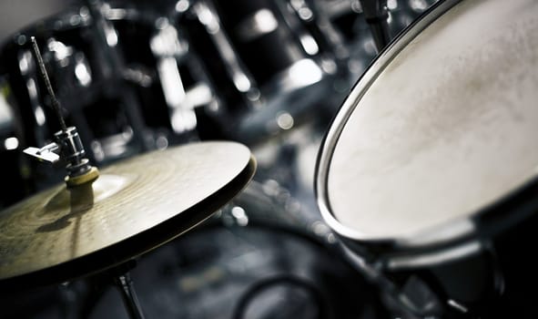 Studio shot of a hi-hat cymbal next to a tom-tom.