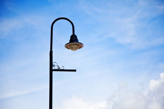 Low angle shot of an old fashioned street lamp against a beautiful blue sky.