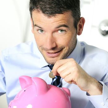 businessman matting a coin in the piggy-shaped pink pig