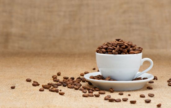 White cup with coffee grains. Grunge background