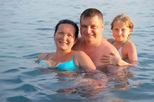 Happy family in the sea. Mum, the father and the daughter