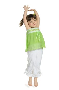 The happy little girl jumps upwards. It is isolated on a white background