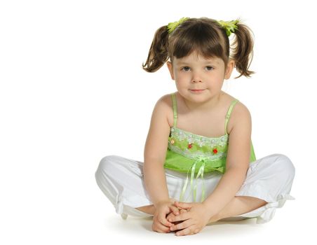 Pretty the little girl sits on the white. It is isolated on a white background