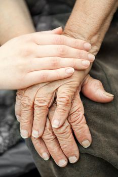 Old and young hands. Hands of the old woman - 84 years covered with young hands