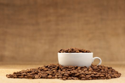 White cup with coffee grains. Grunge background