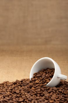 White cup with coffee grains. Grunge background