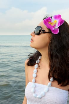 Portrait of the beautiful woman on seacoast. A profile, sun glasses