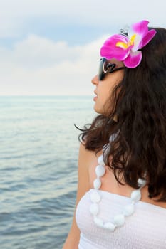 Portrait of the beautiful woman on seacoast. A profile, sun glasses