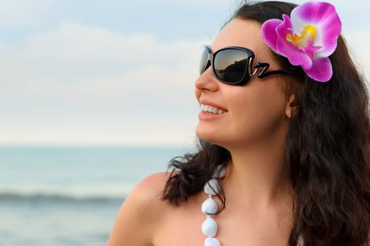 Portrait of the beautiful woman on seacoast. A profile, sun glasses