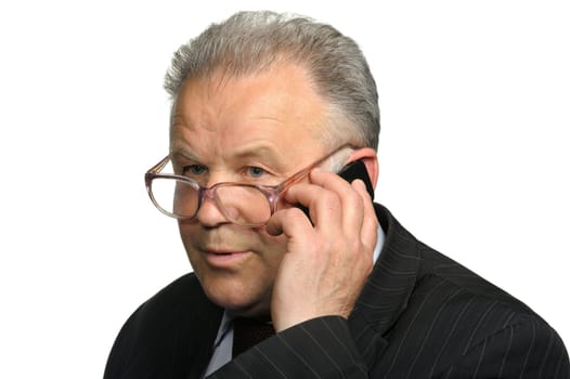 The elderly man talks by a mobile phone. It is isolated on a white background