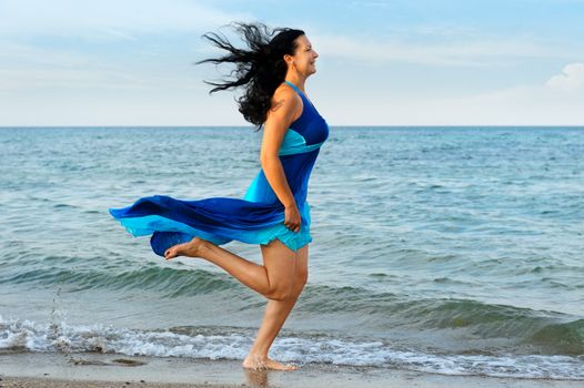 The woman runs on sea coast. A picturesque landscape