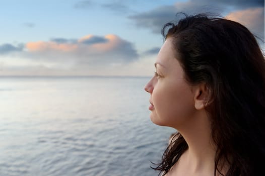 The attractive woman on seacoast and beautiful color sky