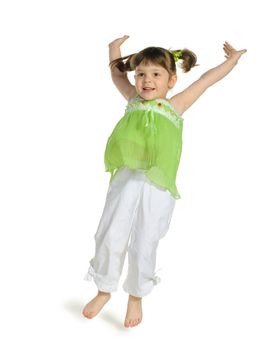 The happy little girl jumps upwards. It is isolated on a white background