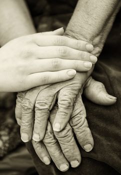 Old and young hands. Hands of the old woman - 84 years covered with young hands