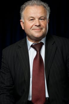 Portrait of the elderly man. A photo against a dark background