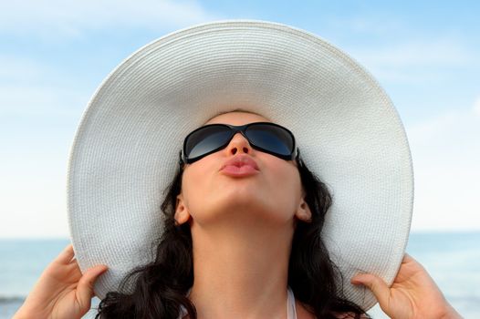 Portrait of the young woman in a hat. Seacoast, a close up