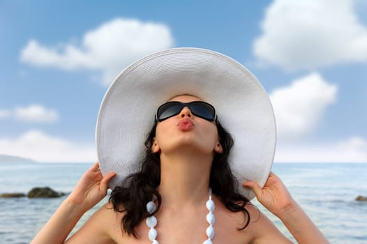 Portrait of the young woman in a hat. Seacoast, a close up