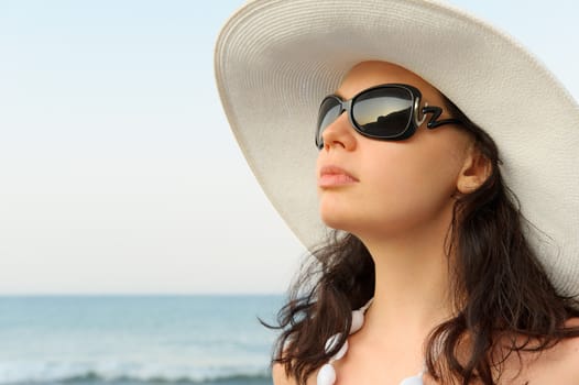 Portrait of the young woman in a hat. Seacoast, a close up