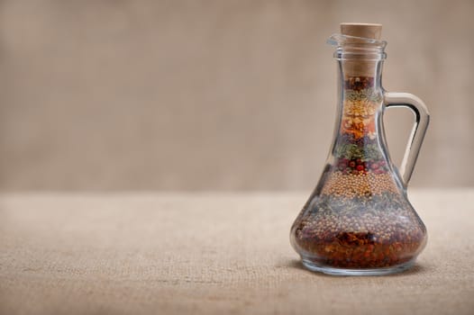 Bottle of spices. Capacity with a set of various spices on a rough background.