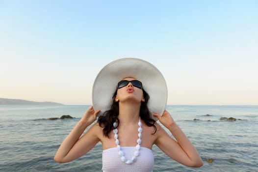 Portrait of the young woman in a hat. Seacoast, a close up