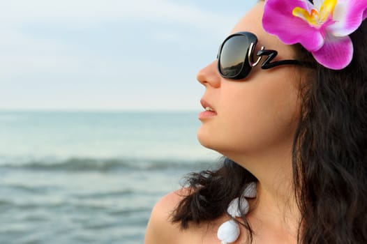 Portrait of the beautiful woman on seacoast. A profile, sun glasses