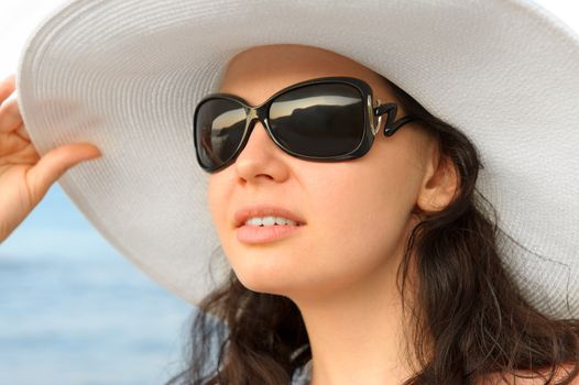 Portrait of the young woman in a hat. Seacoast, a close up