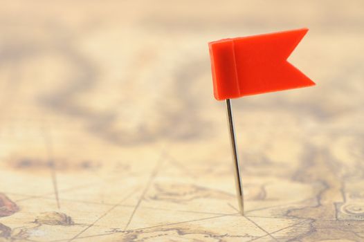 Flag red a pin on old map. Photo closeup. Selective focus