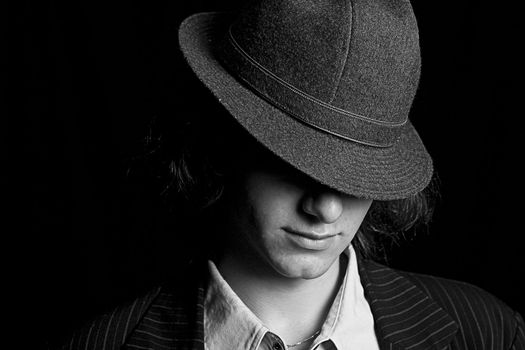 black and white portrait male teenager with a hat tipped over the eyes