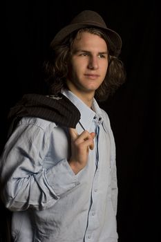 Male teenager wearing a suit and hat, with coat over his shoulder