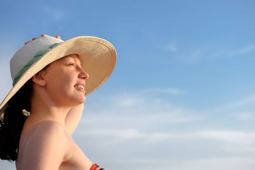 The girl in a hat against the blue sky