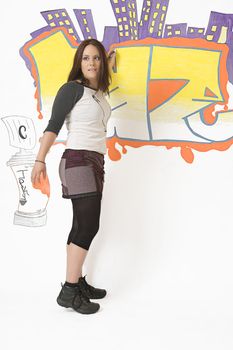 Teen girl keeping an eye out while doing a graffiti on a wall